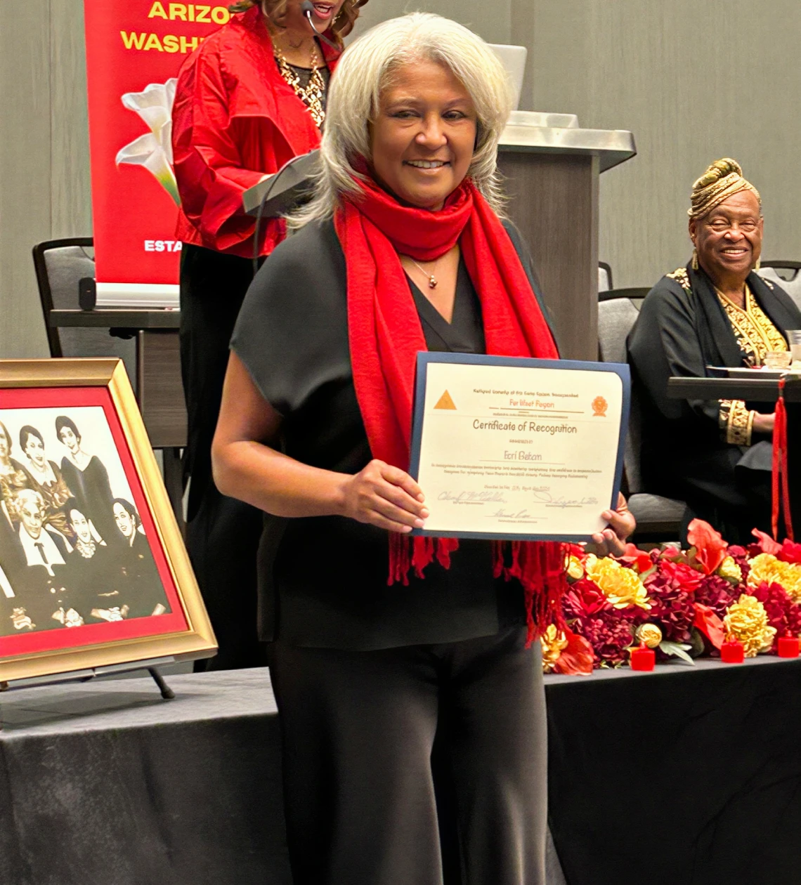 Smiling woman with framed certificate
