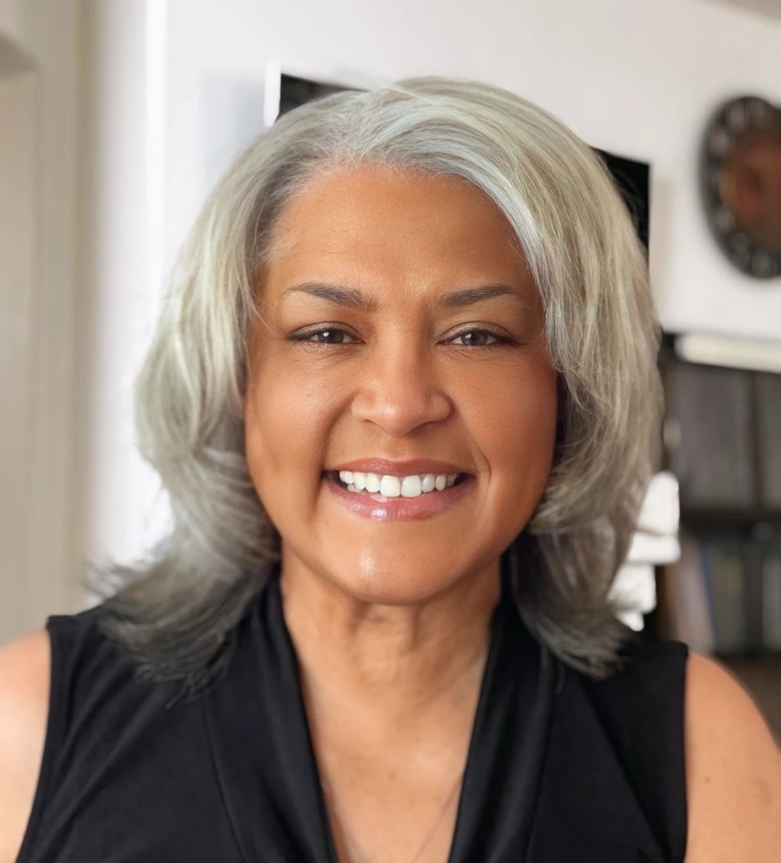 Smiling woman with gray hair indoors.