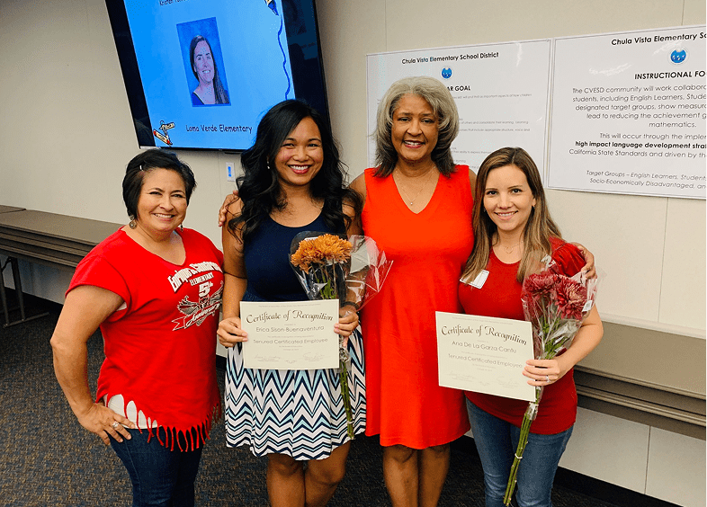 Group celebrating with certificates and flowers